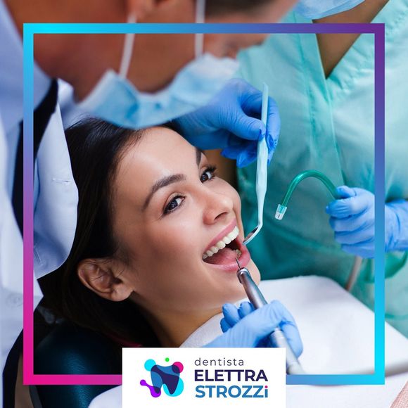 Dentista che esamina la bocca aperta di una paziente sorridente con le mani guantate di blu in una clinica, logo in basso.