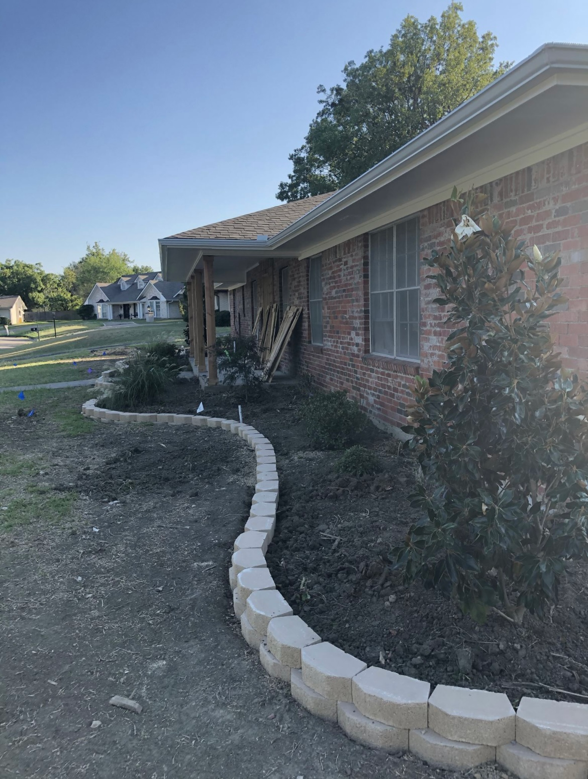 Brick house with a curved stone-edged garden bed along the front yard