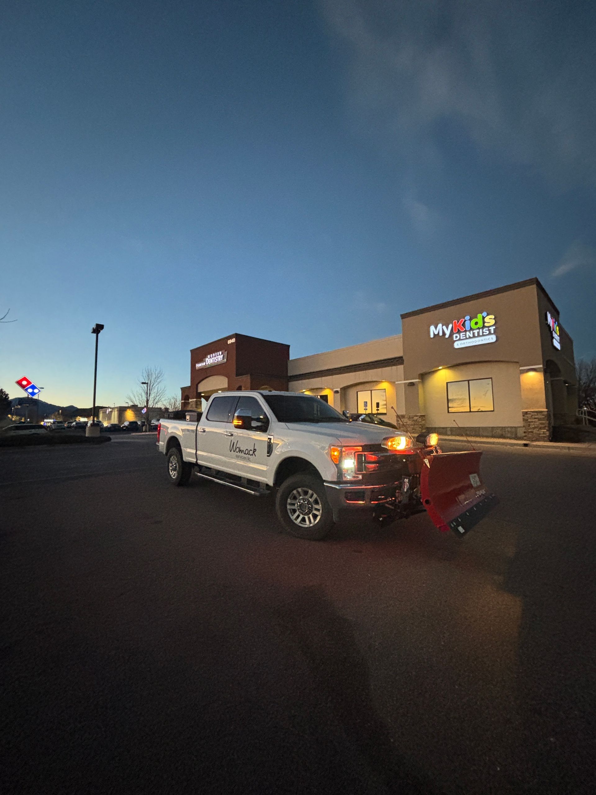 White pickup truck with red lights parked outside a MyPlace hotel at dusk