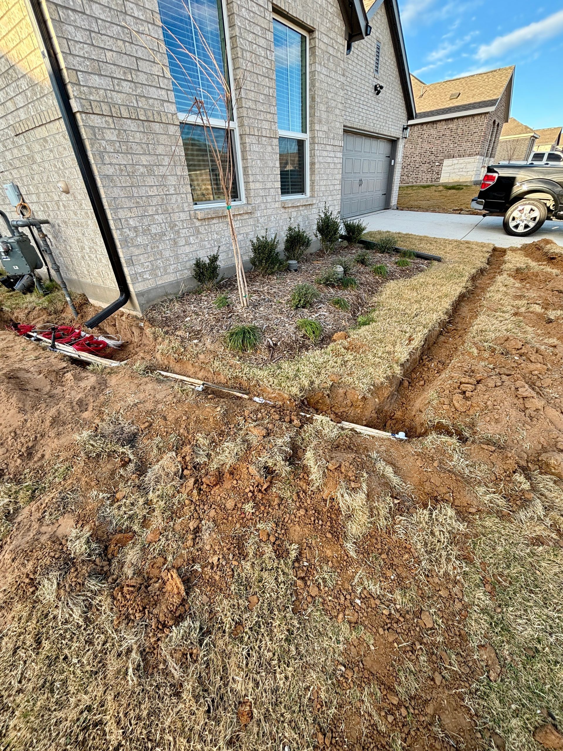 New house exterior with gravel landscaping and a driveway beside a parked truck