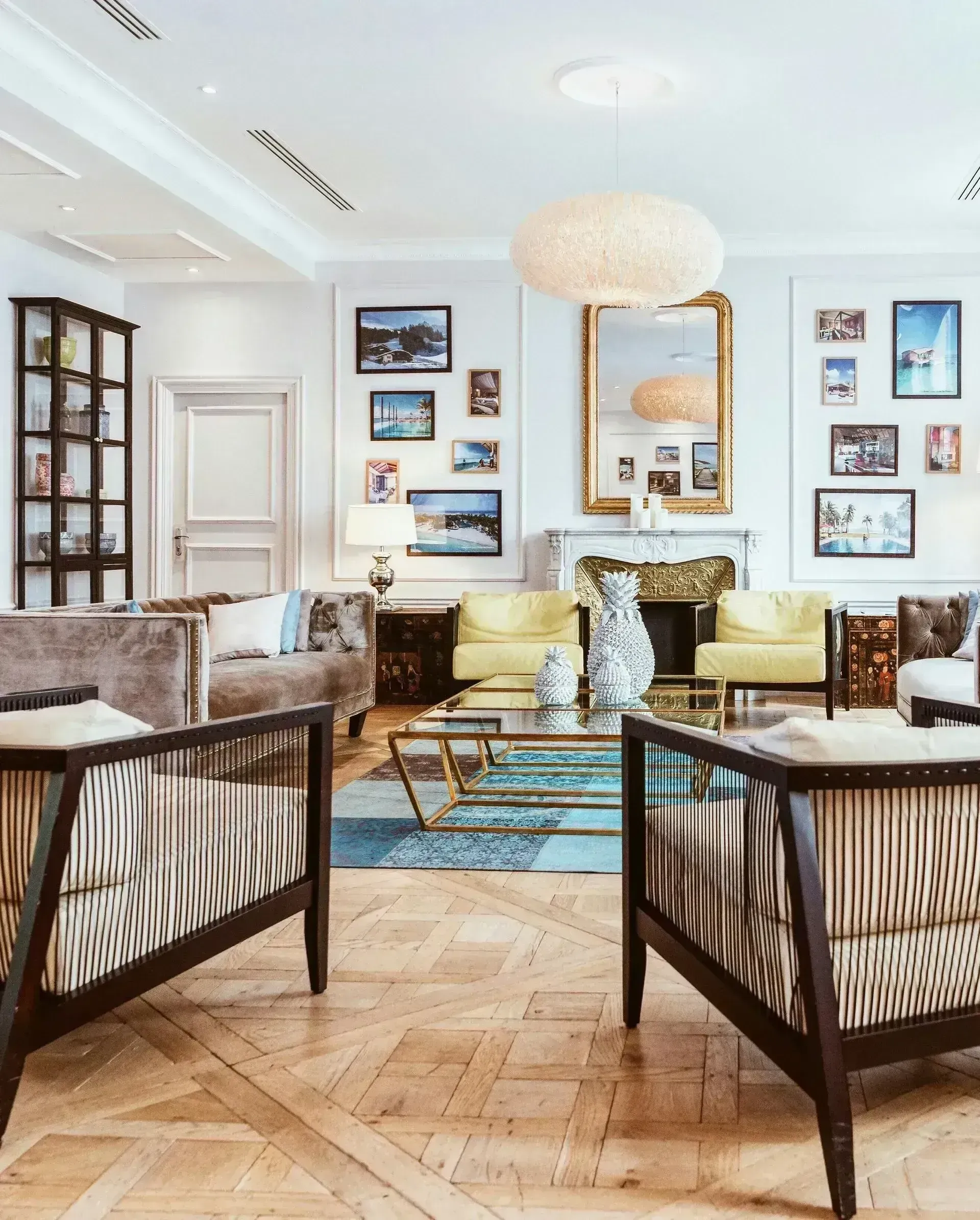 Elegant living room with patterned sofas, blue rug, framed art, and a large ornate mirror