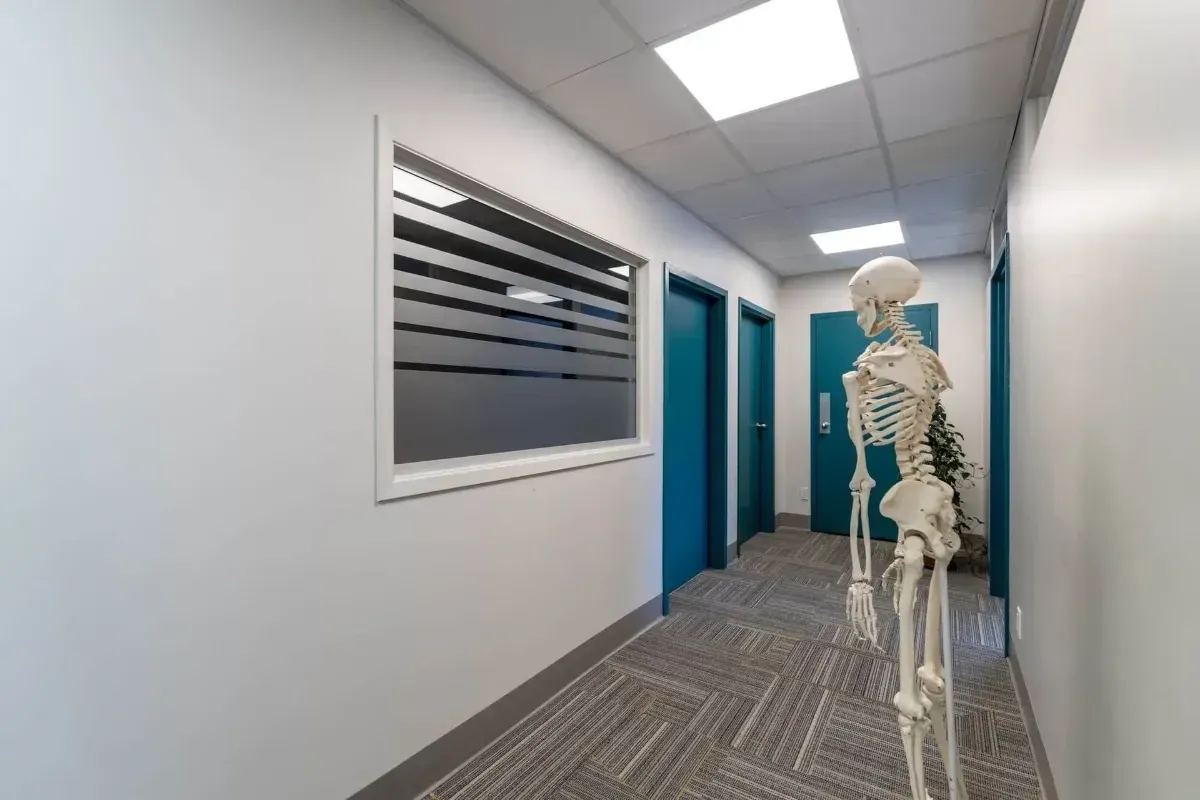 Skeleton model in a modern hallway beside blue doors and wall art