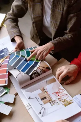 People reviewing color swatches and design layouts on a table