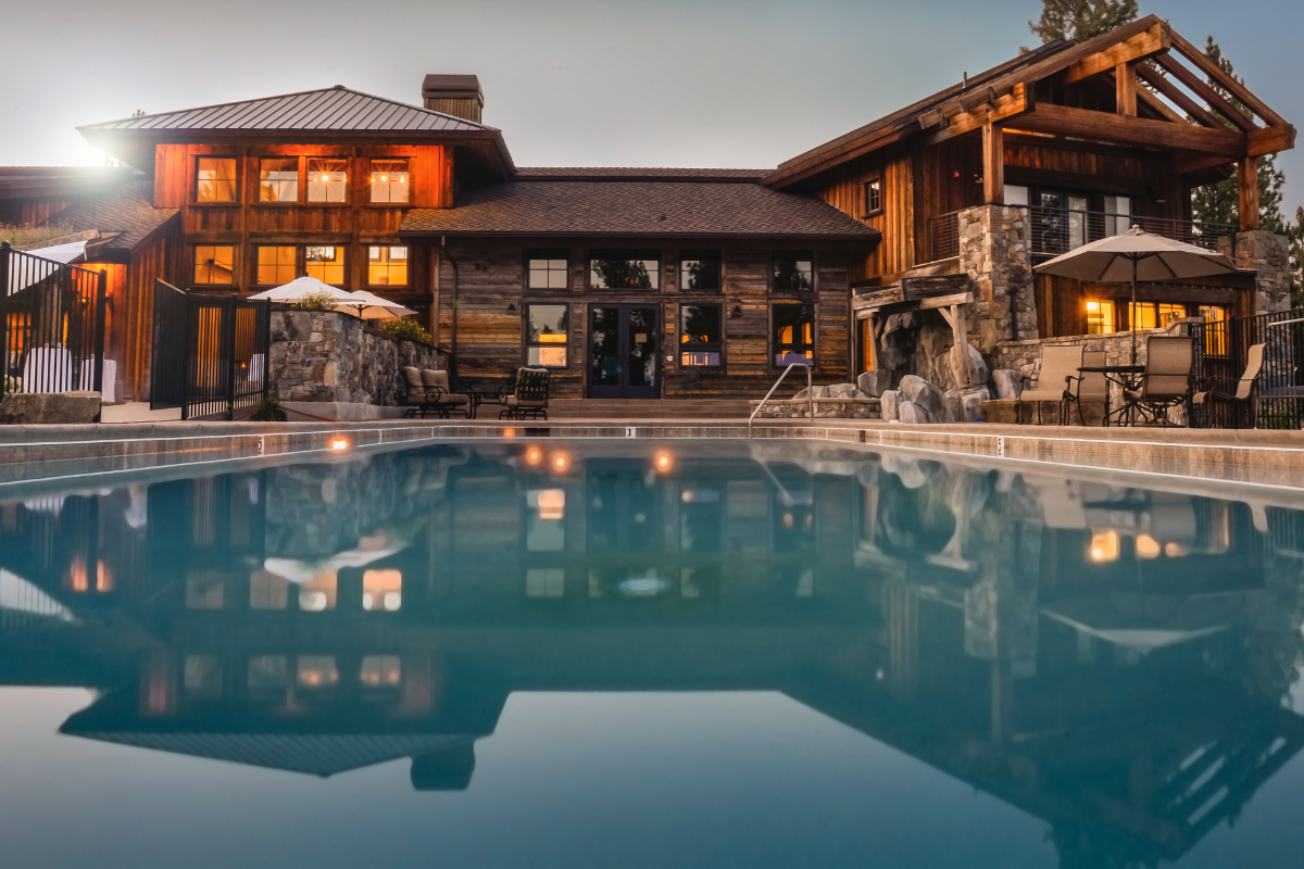 A large house with a swimming pool in front of it.