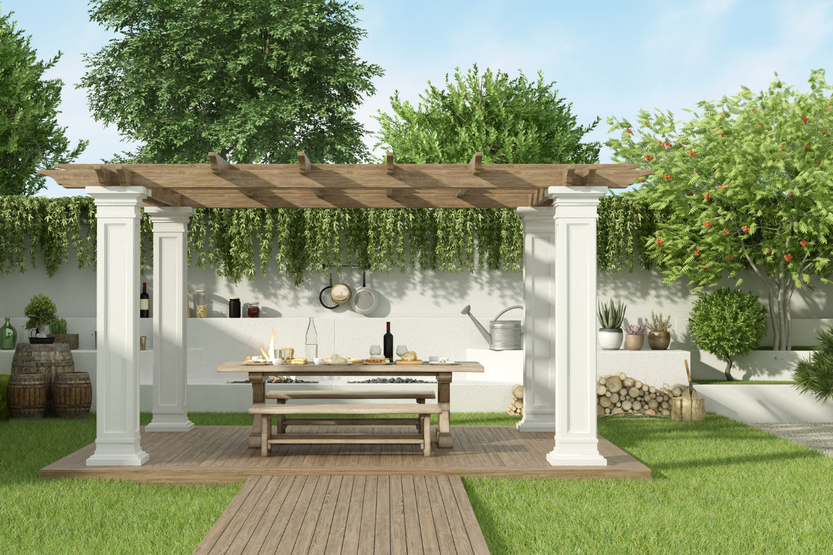 A pergola with a table and bench underneath it in a backyard.