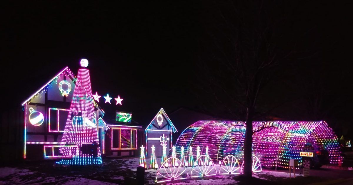 A house is decorated with lots of christmas lights at night.
