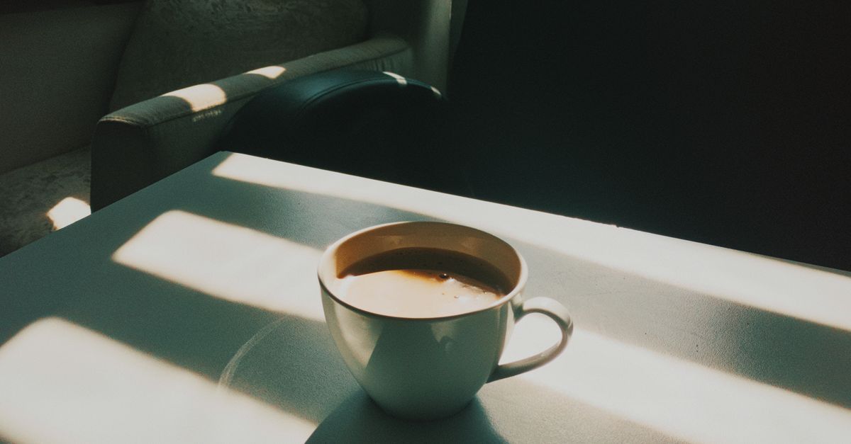 Person taking a quiet moment by a bright window at home while selling a house during a separation