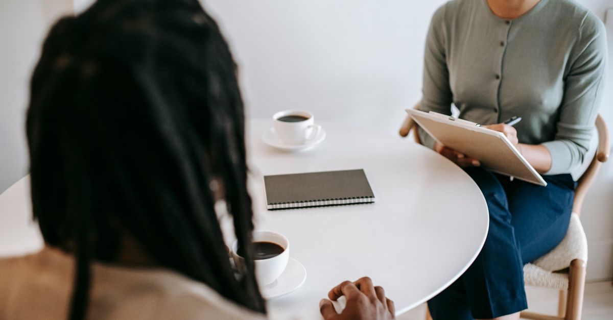 Supportive conversation between a professional and a client at an office table during a separation
