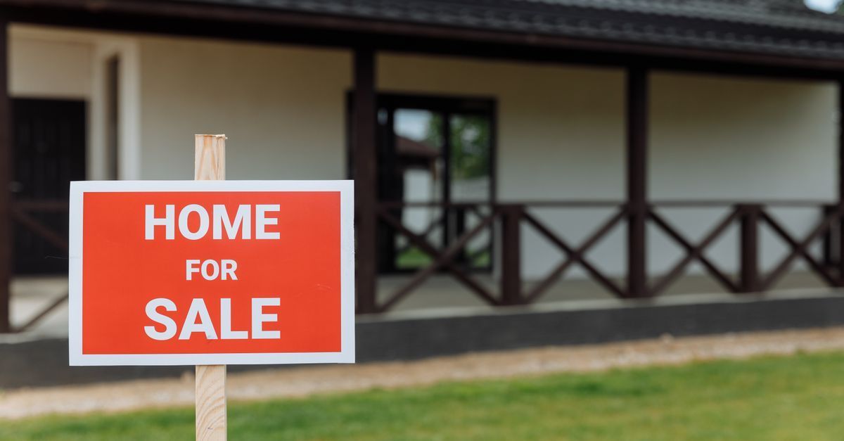 Family home on a quiet Milton, Ontario street in September with a For Sale sign on the lawn