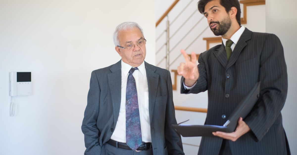 Two real estate agents from one team reviewing a listing agreement for a divorce sale in Milton