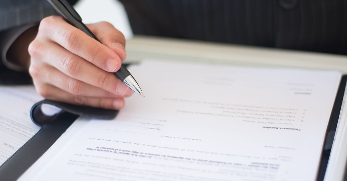 Signing a separation agreement at a kitchen table before selling a home in Milton, Ontario