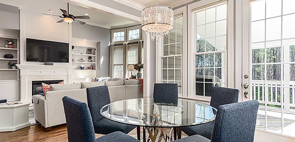 a dining room with a glass table and chairs and a chandelier .