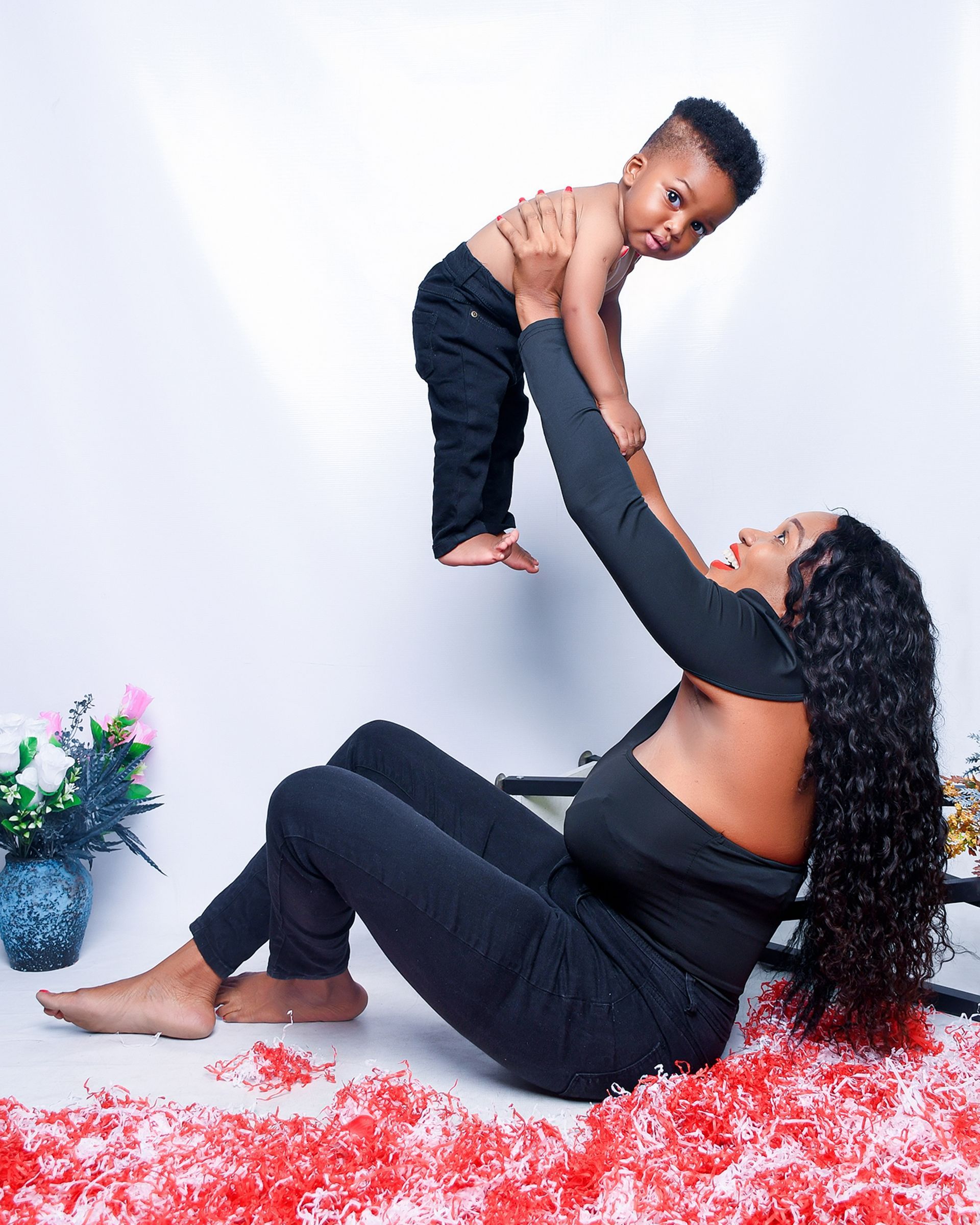 A woman is holding a baby up in the air.