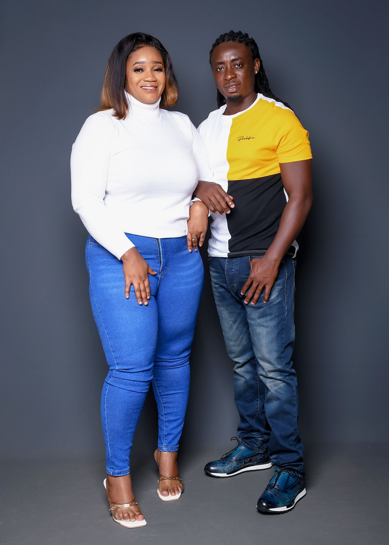 A man and a woman are standing next to each other holding hands.