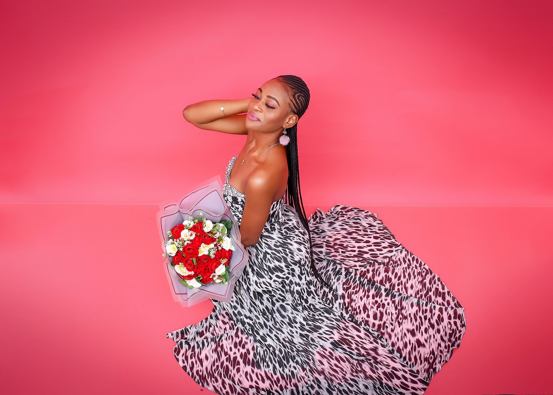A woman in a leopard print dress is holding a bouquet of flowers.