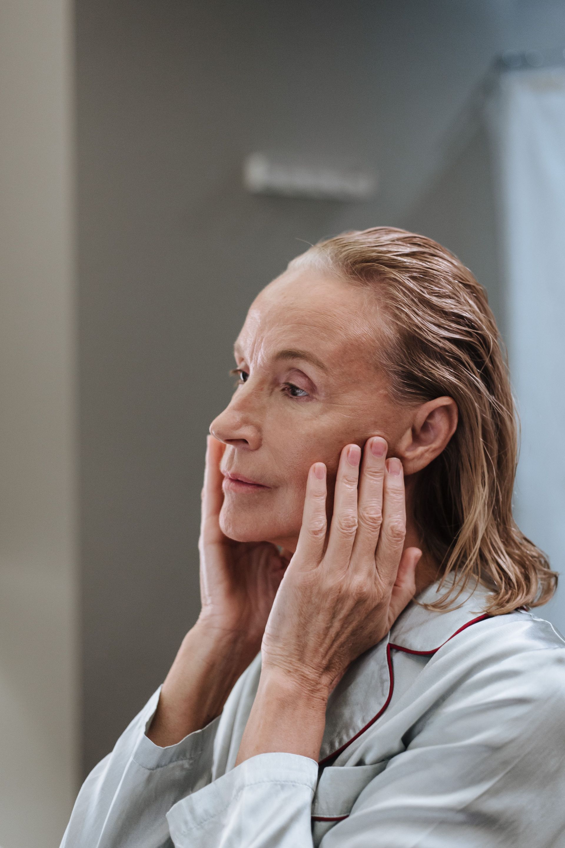 Woman checking her face in the mirror