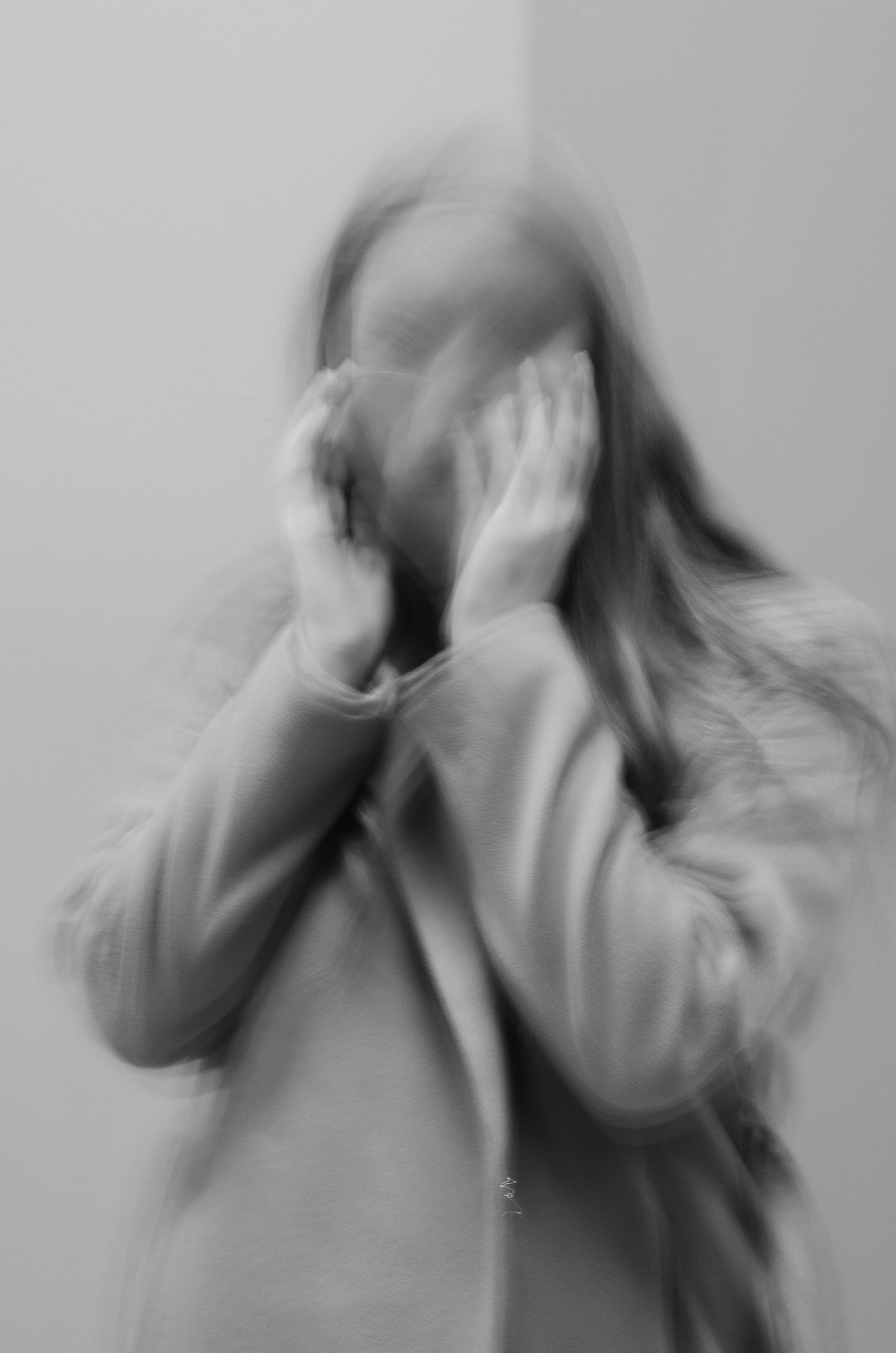 Person holding head with faded effect