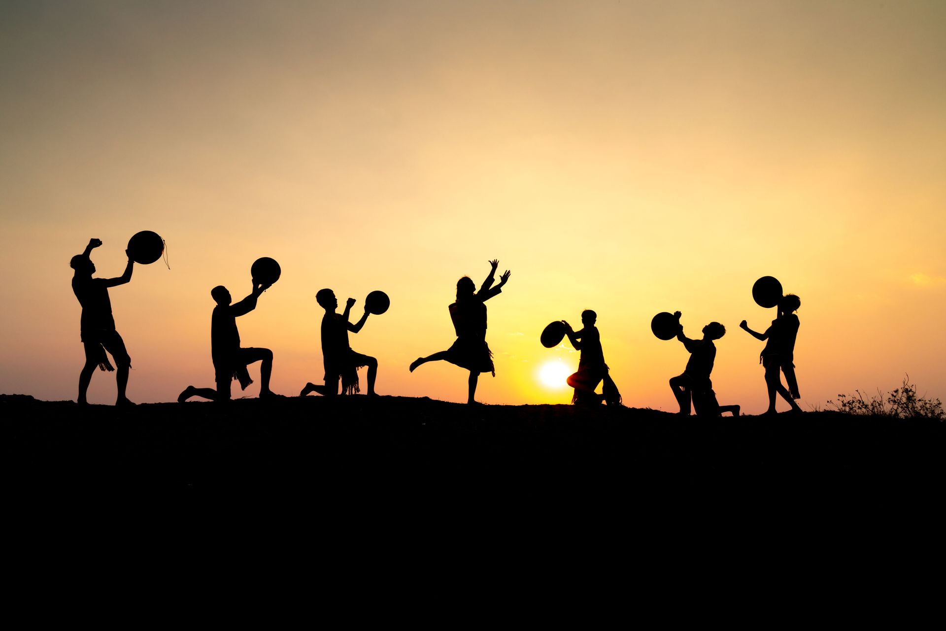 group of people as shadows with instruments and dancing