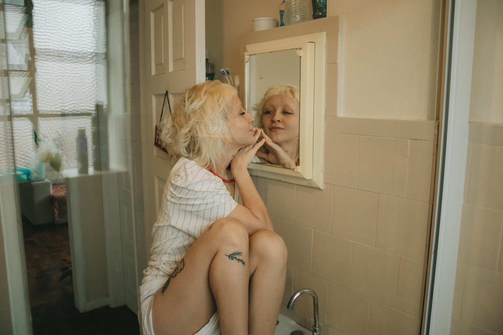 Woman in bathroom gazing at her reflection in the mirror