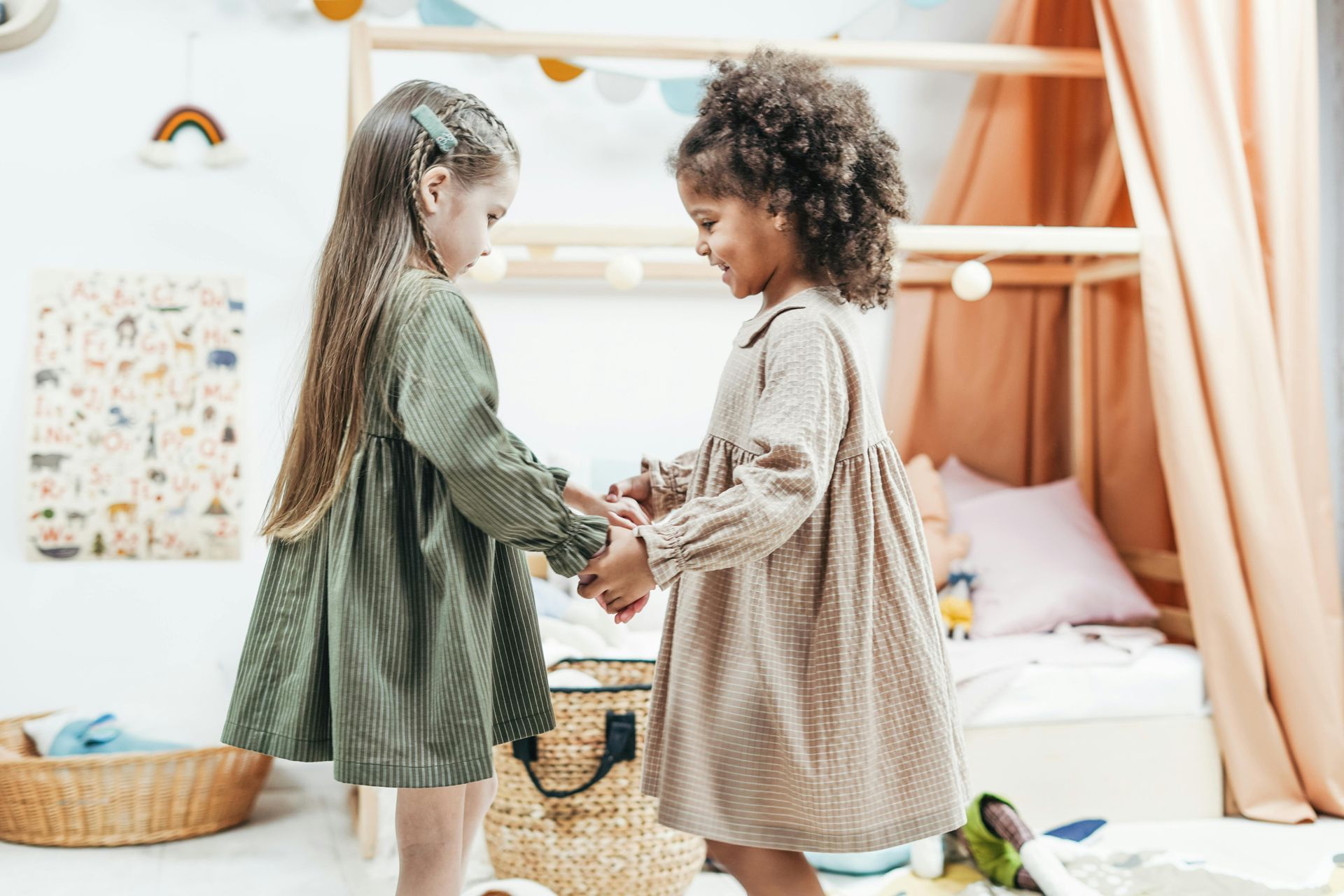 Two young children holding hands while playing