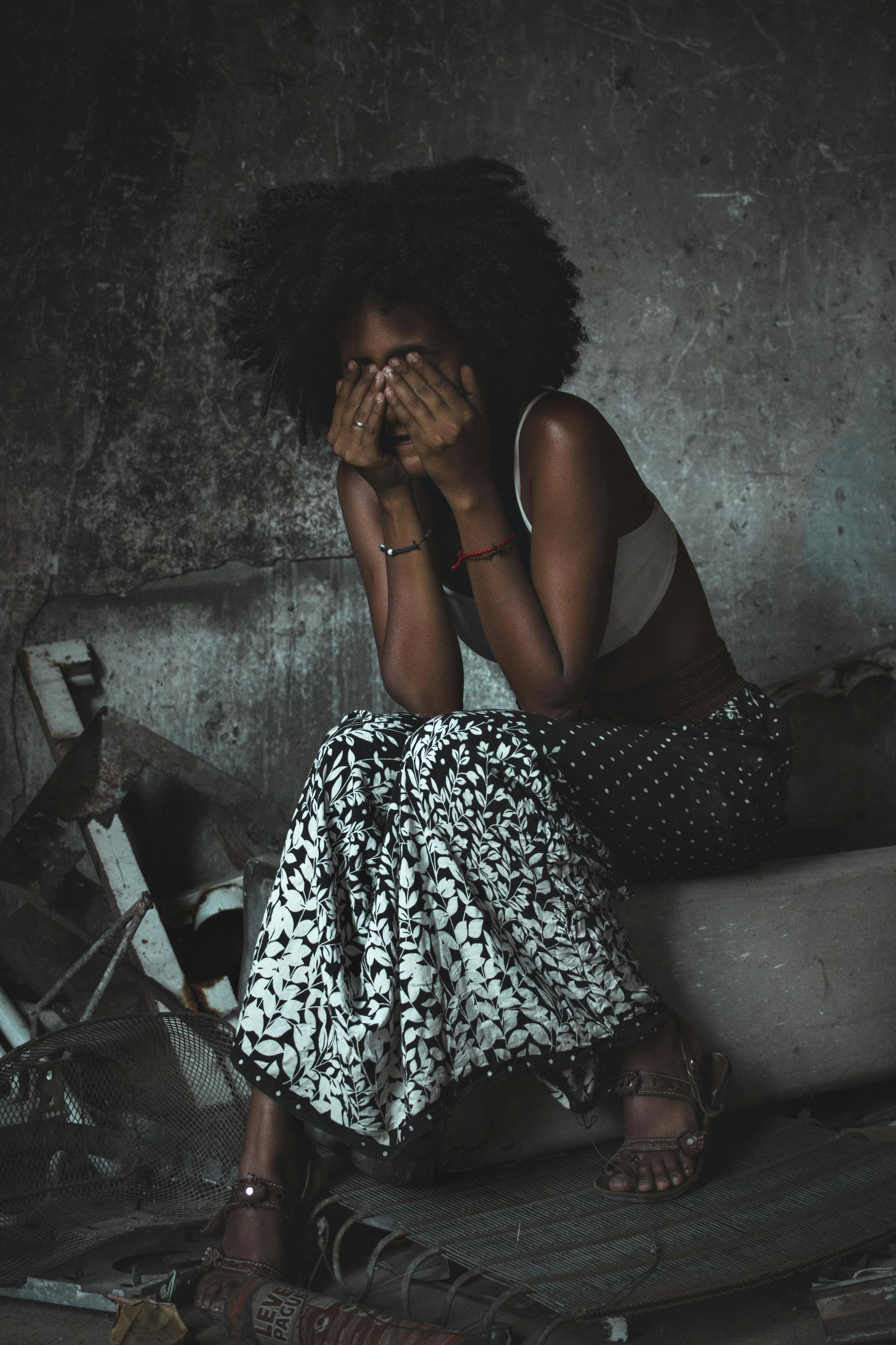 Woman sitting down with head in hands
