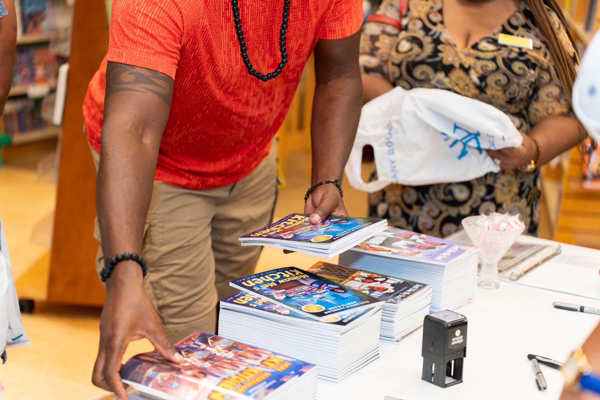 A man and a woman are looking at books on a table.
