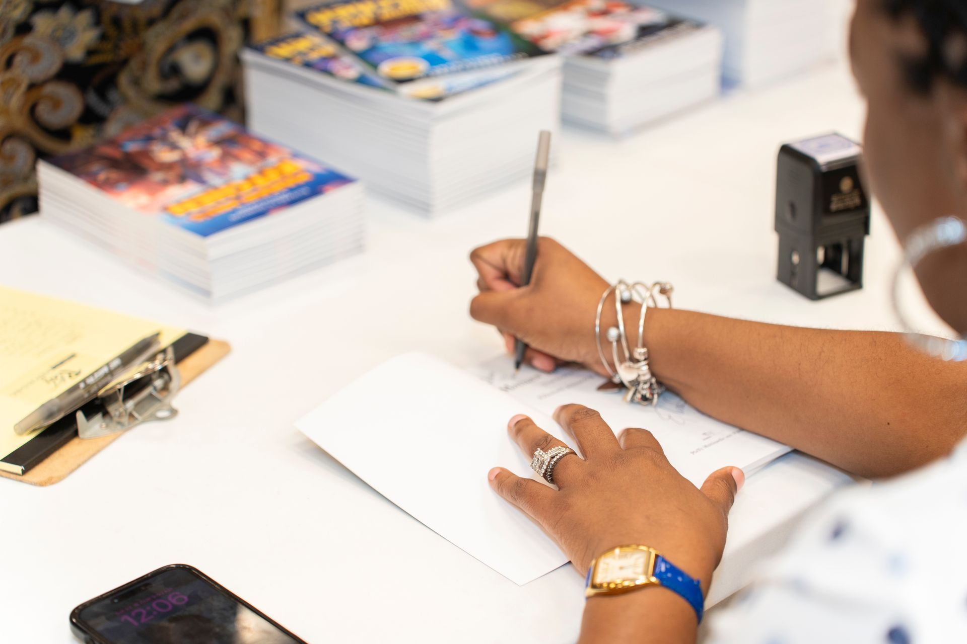 A woman is sitting at a table writing in a notebook.