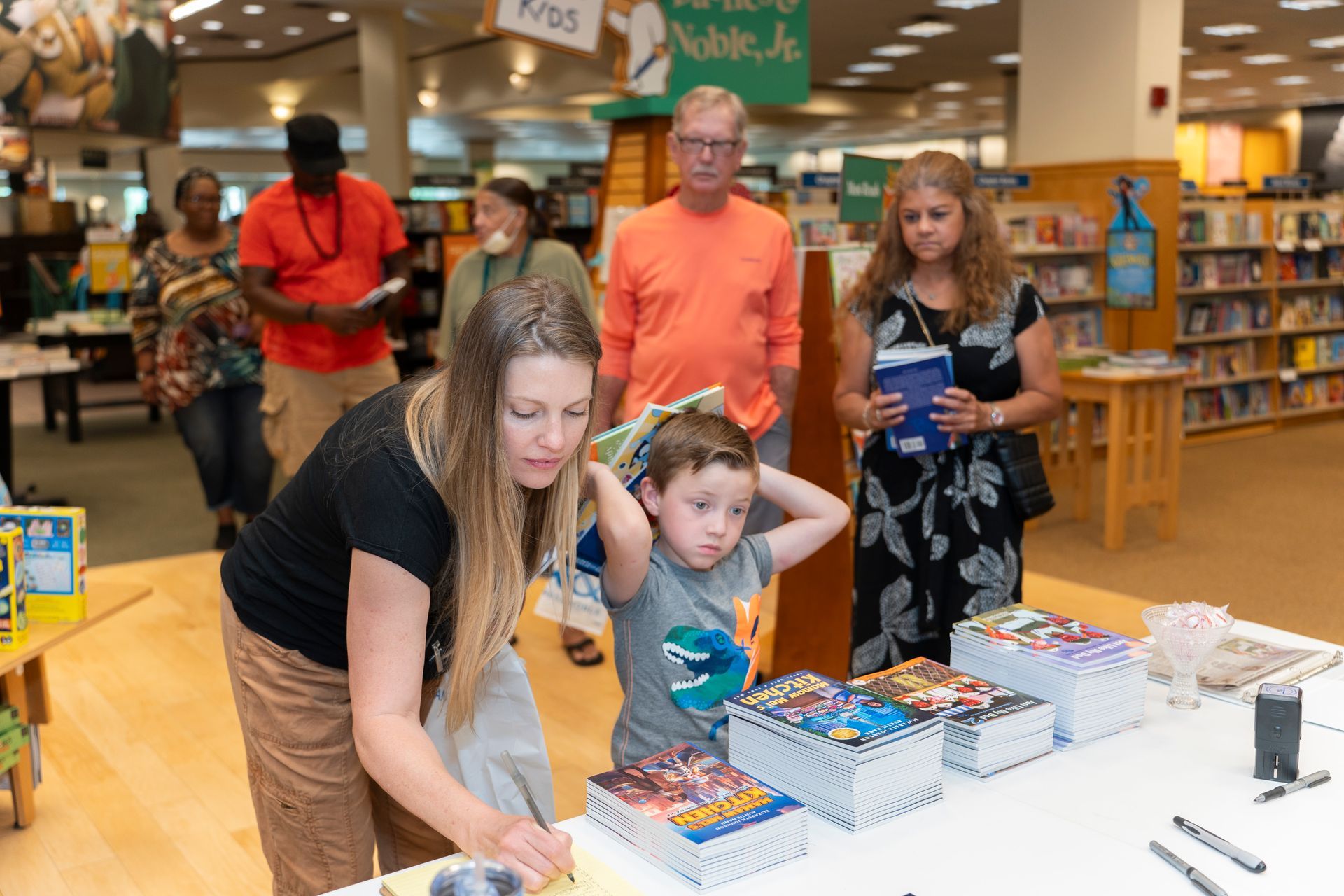 A woman and a child are looking at books in a bookstore.