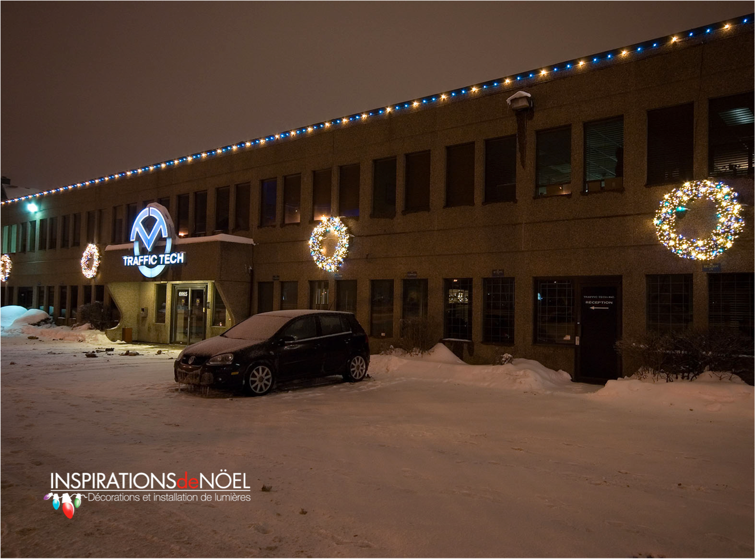 A car is parked in front of a building decorated for christmas