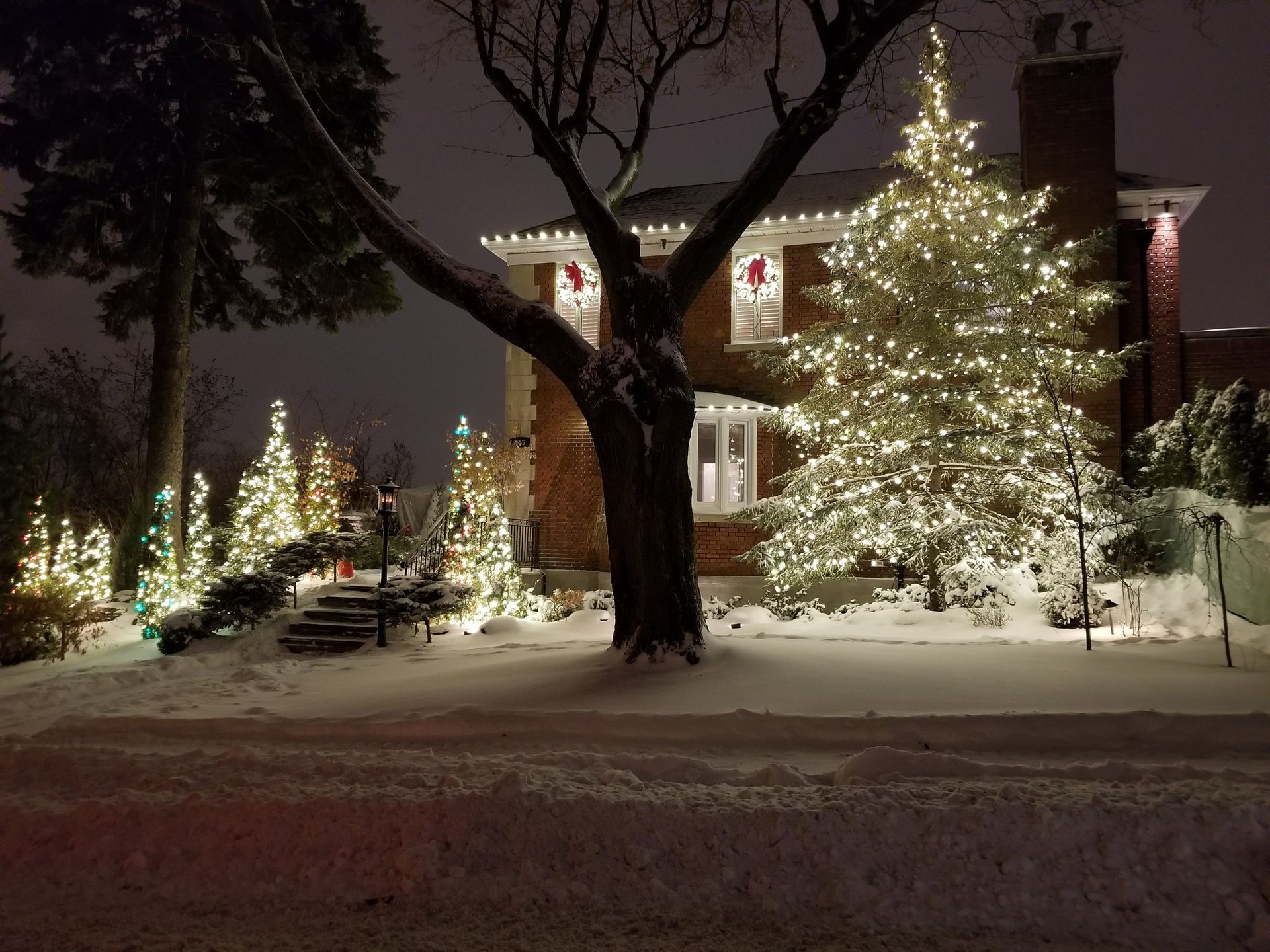 A house is decorated with christmas lights and snow