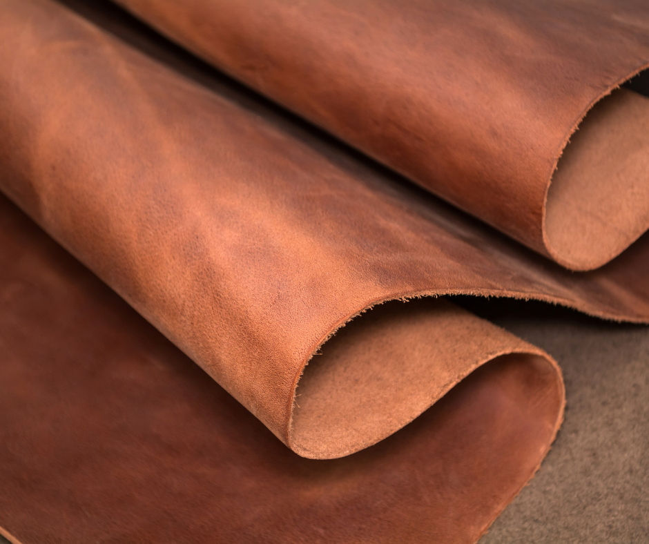 Brown leather sheets rolled and layered on a textured surface