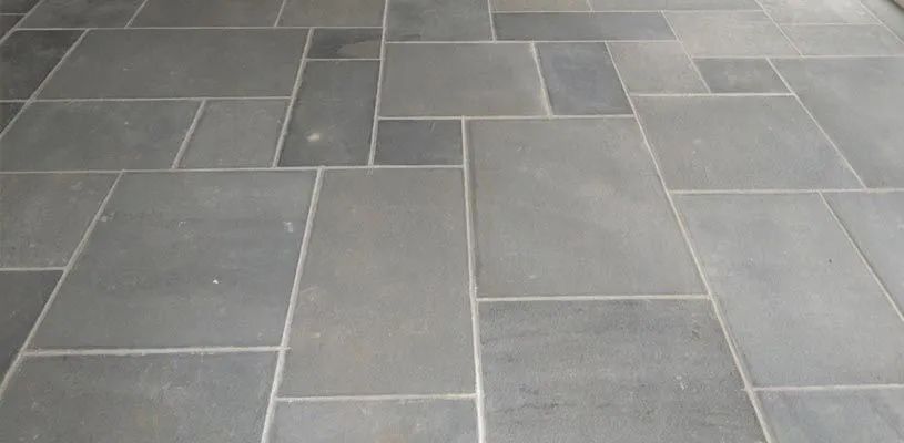 Gray stone tile floor with rectangular paving stones and light grout lines