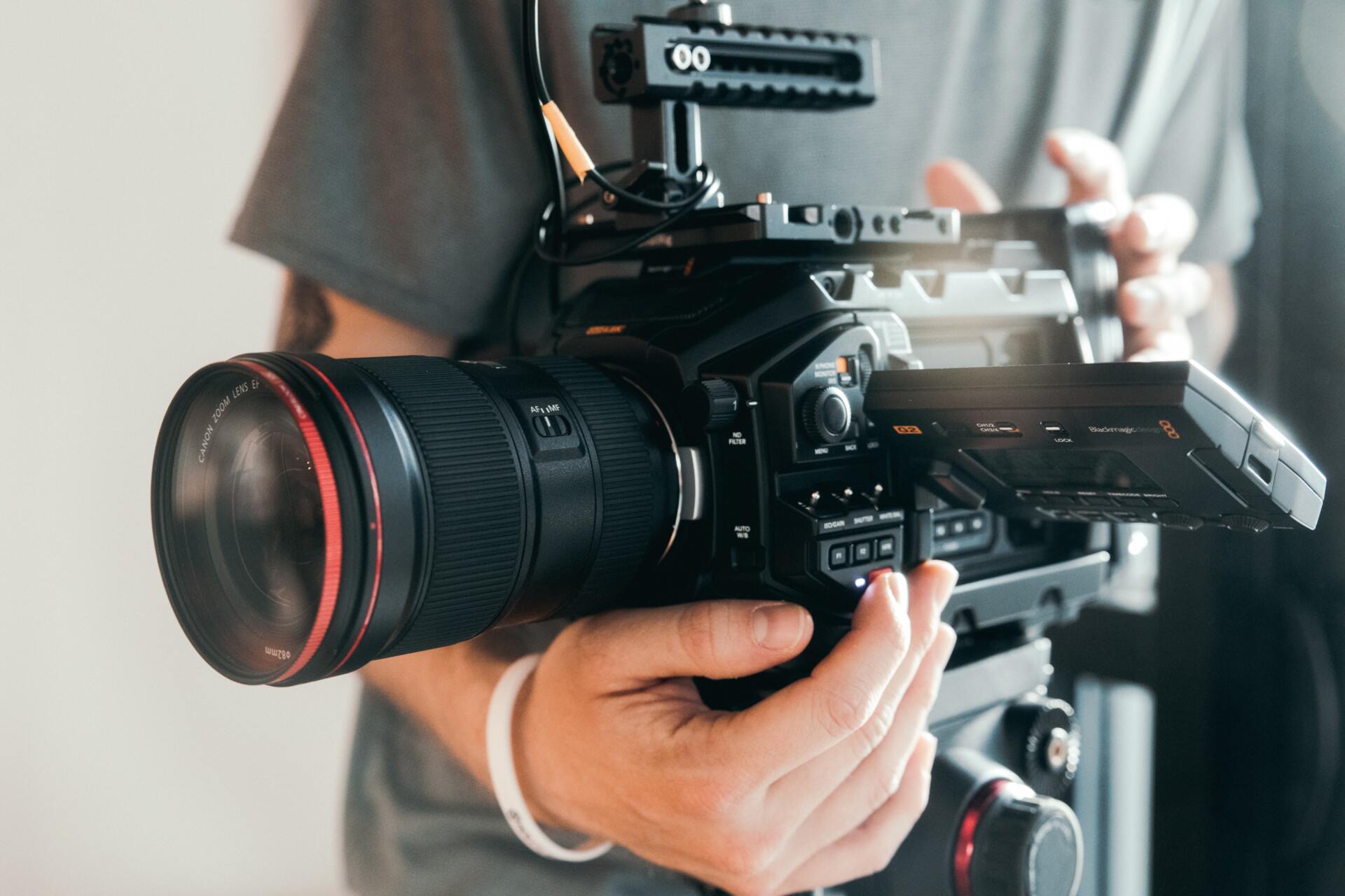 a camera setup to record video recording with a blurred black man in the background on a sofa