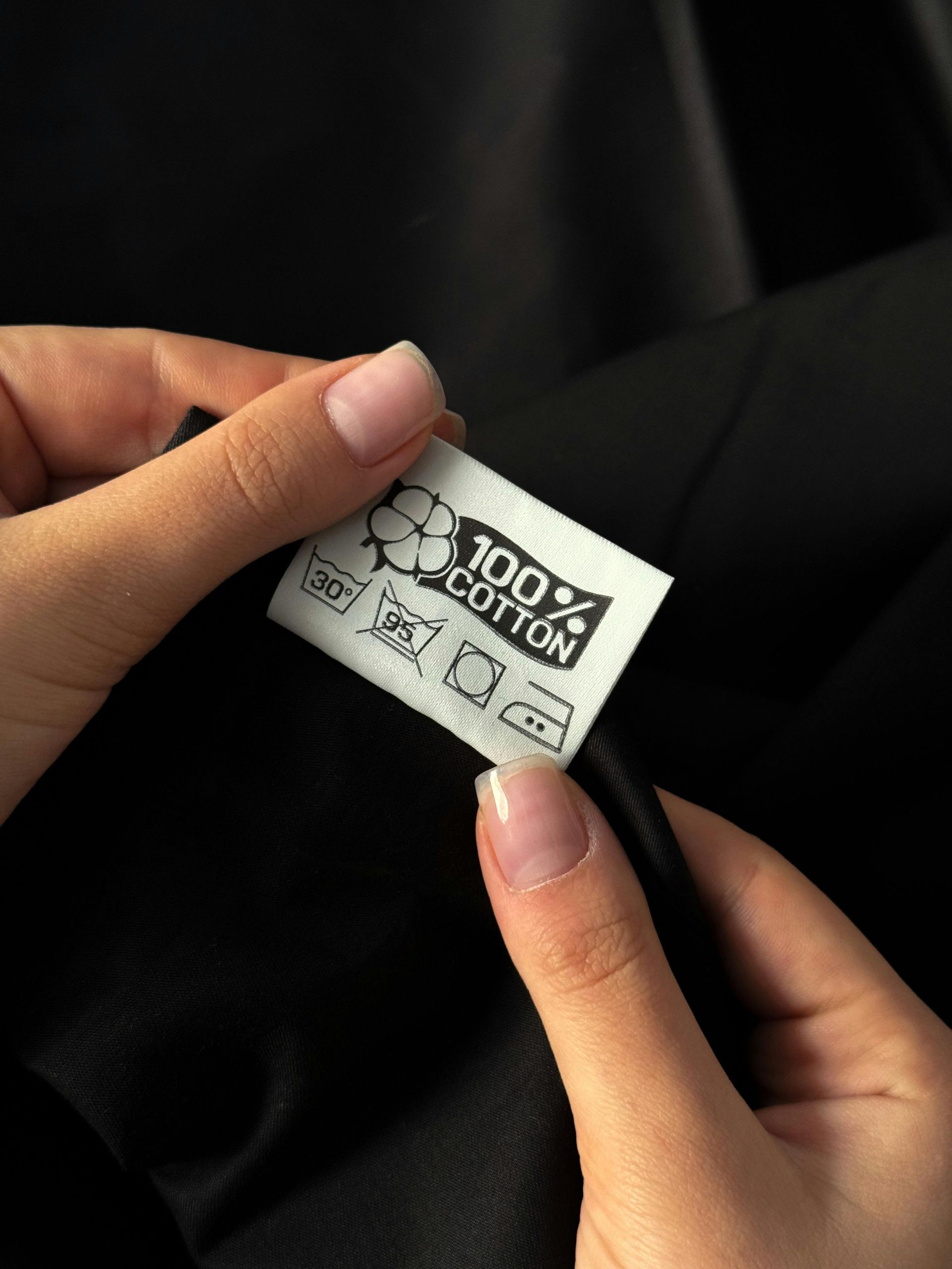Hands holding a clothing tag that reads