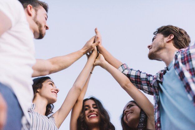 Un grupo de personas se están dando unos cinco.