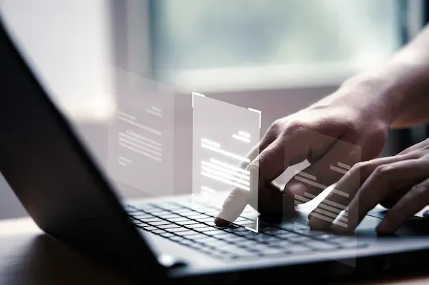 Una persona está escribiendo en una computadora portátil con un gráfico en la pantalla.