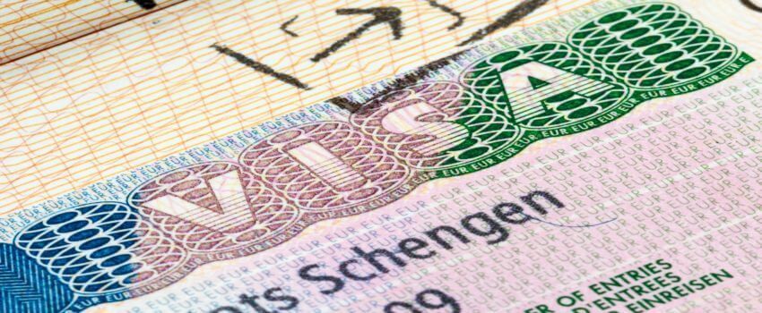 Un primer plano de una visa Schengen encima de otra visa.