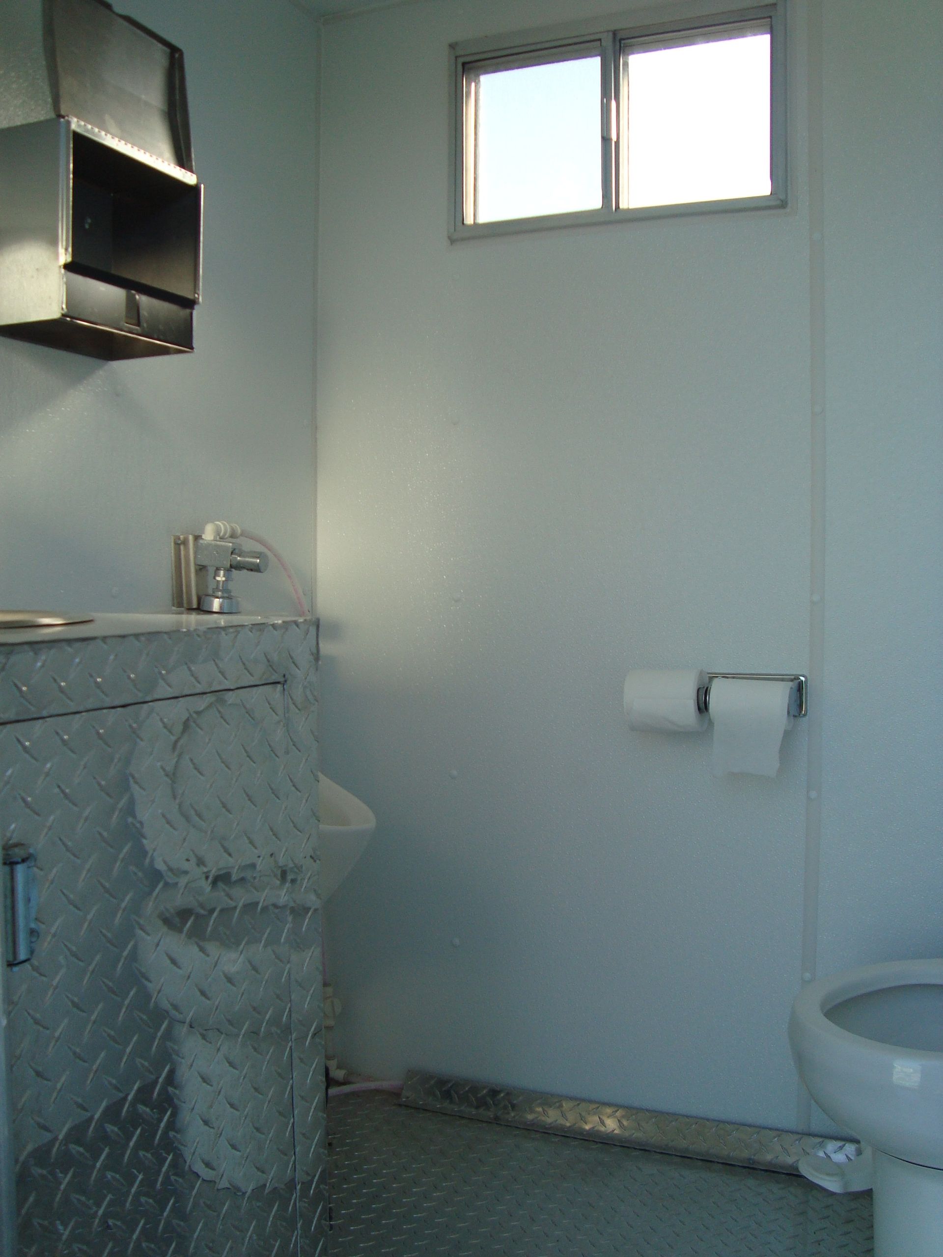 A bathroom with a toilet a sink. Portable toilets. Brazeau Sanitation