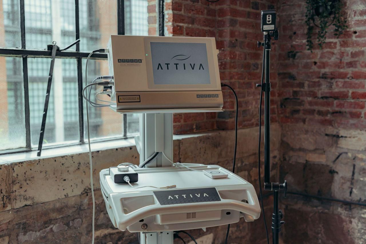 A computer is sitting on a stand in front of a brick wall.