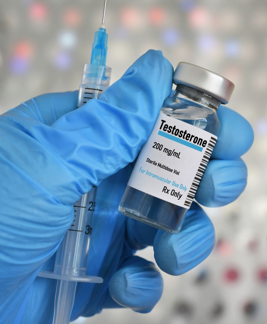 A person wearing pink gloves is holding a syringe and a bottle of vaccine.