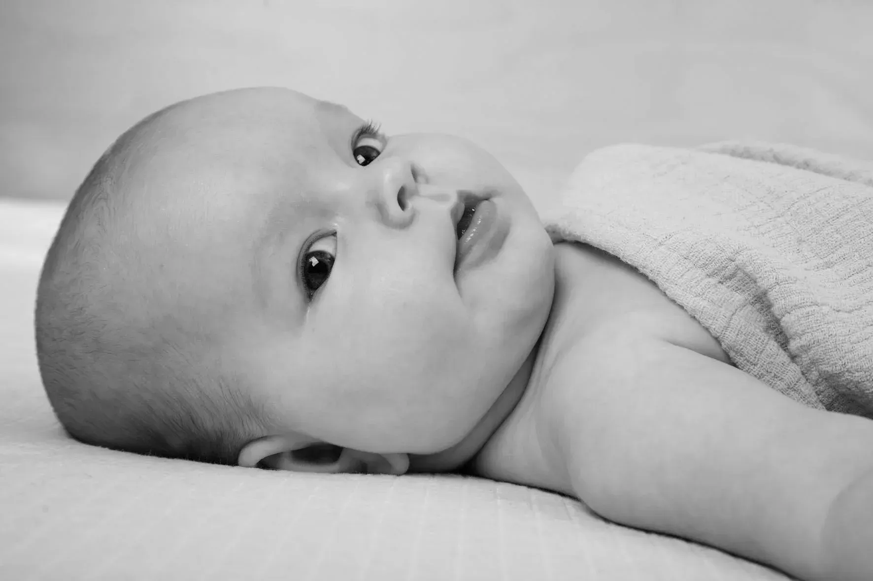Baby liegt bei einer Baby-Homestory entspannt auf einer Decke