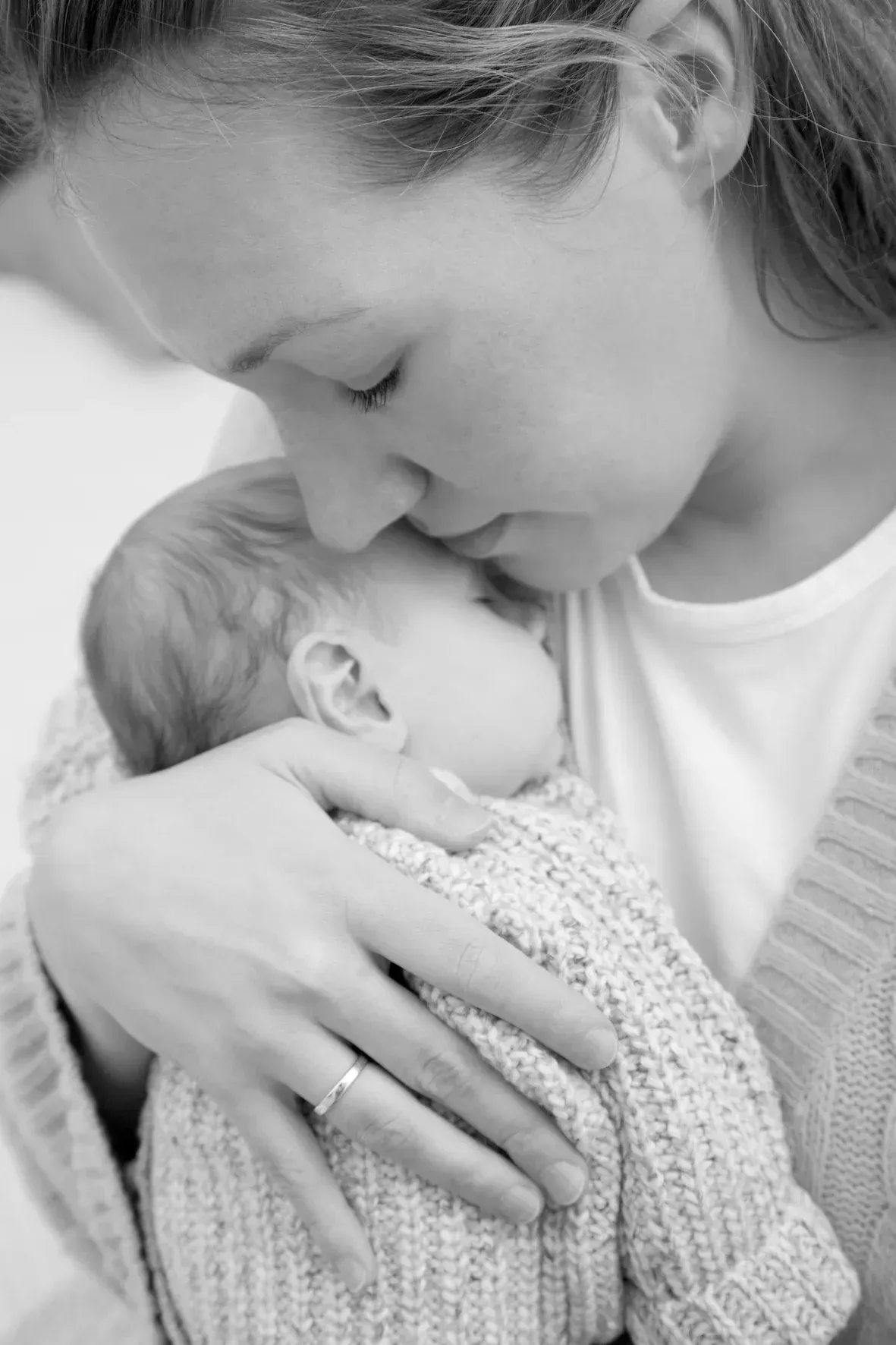 Mutter hält ihr Baby liebevoll im Arm bei einer Baby-Homestory