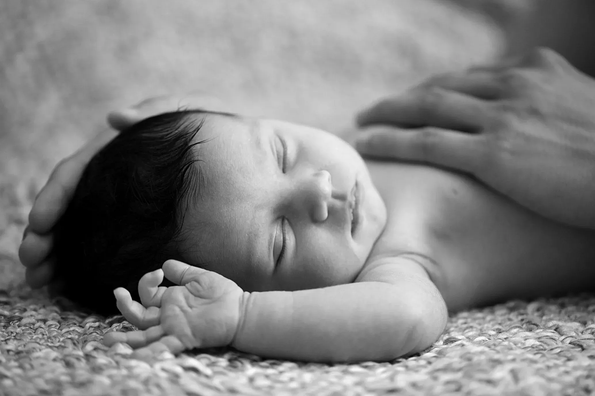 Schlafendes Baby mit einer Hand auf der Brust bei einer Baby-Homestory Schlafendes Baby mit einer Hand auf der Brust bei einer Baby-Homestory