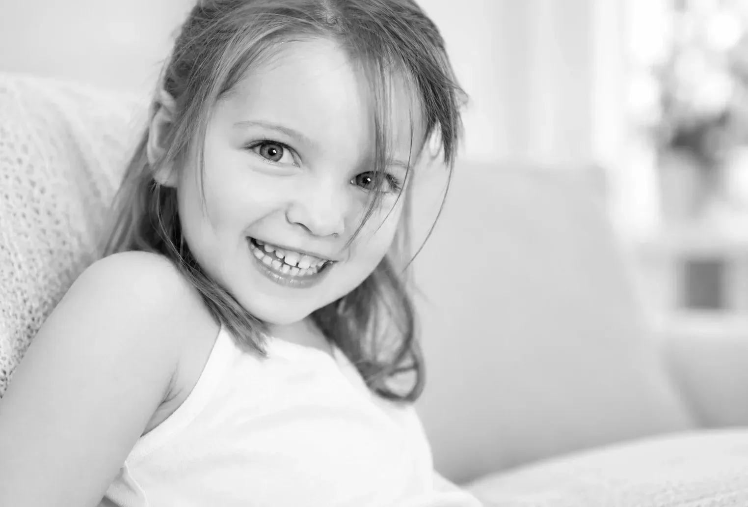 Natürliches Kinderporträt in Schwarz-Weiß Lachendes Mädchen in einem natürlichen Schwarz-Weiß-Porträt