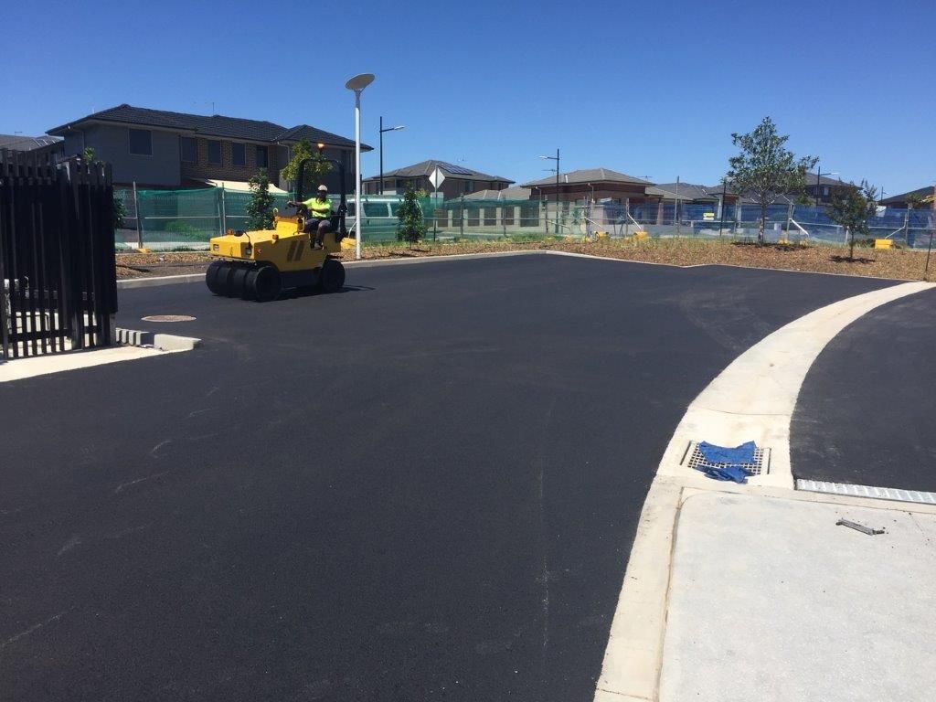A Large Parking Area with Heavy Machine Equipment Colour Yellow — Sydney, Nsw — C & C Asphalt Pty Ltd