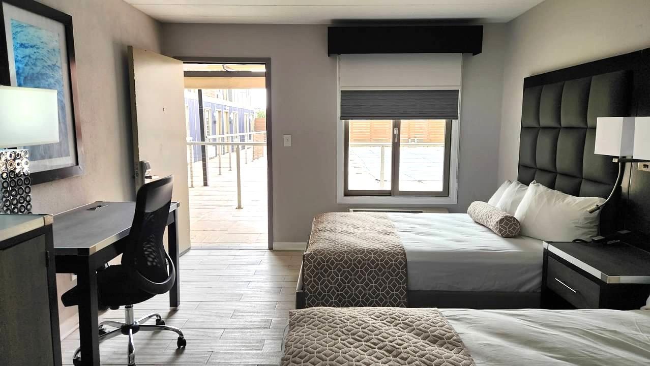 A hotel room with two beds , a desk and a chair.