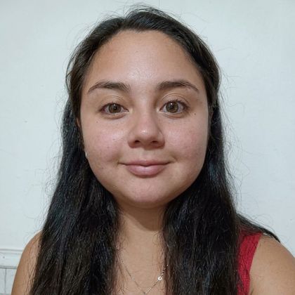 Retrato de una persona con el pelo largo y castaño sobre un fondo liso y claro, que lleva una prenda oscura.