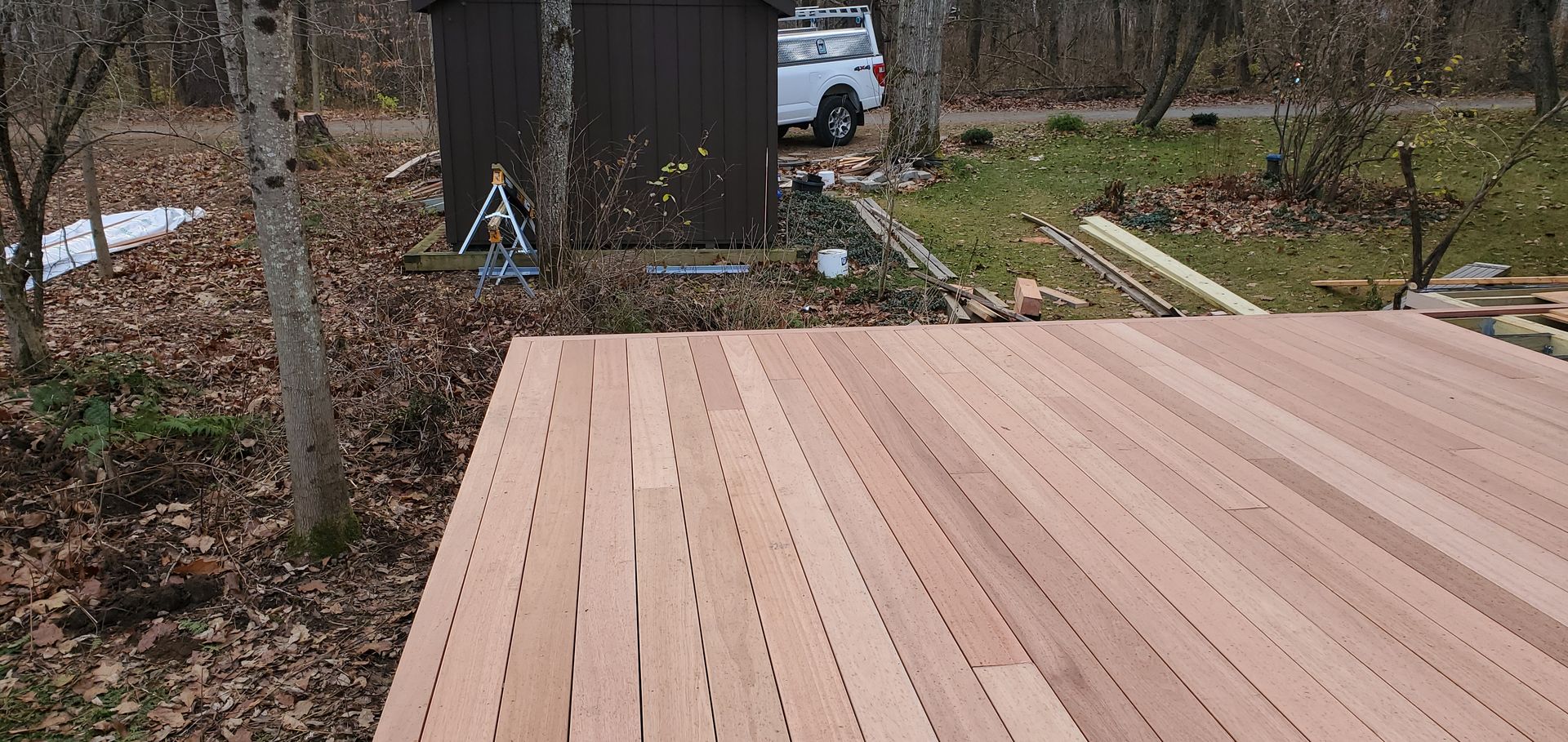 A wooden deck with a shed in the background