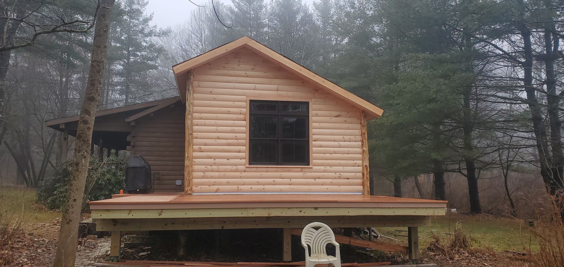 A small log cabin in the middle of a forest