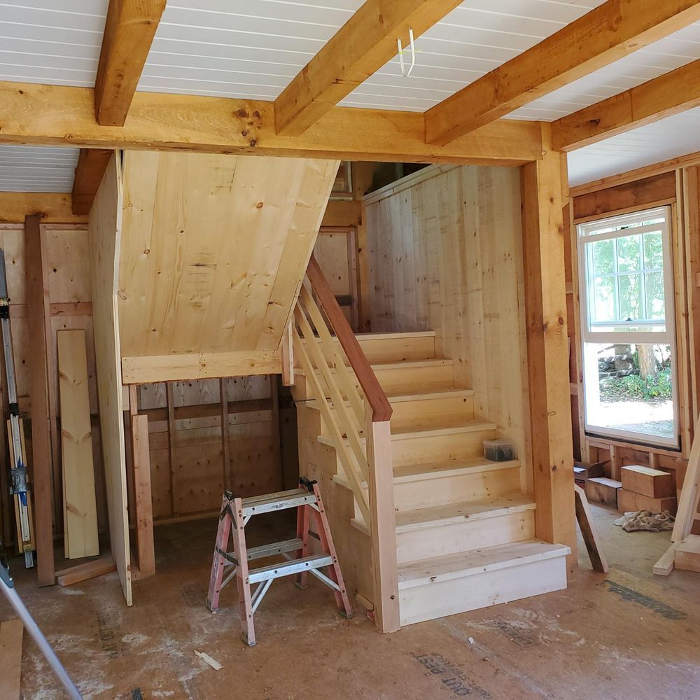 A wooden staircase with a ladder in front of it